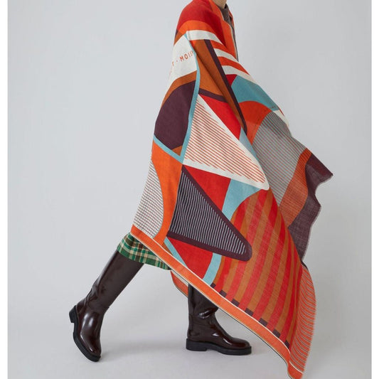 Person wearing a colorful patterned scarf with a plain background